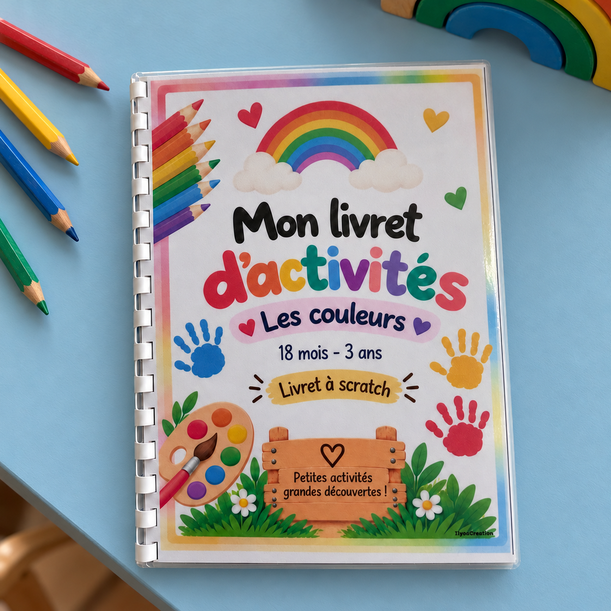 Livret d’activités Les couleurs A5, sur une table bleu clair avec crayons de couleur
